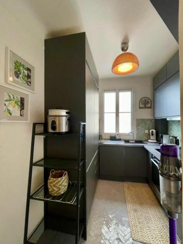d'une cuisine équipée d'un réfrigérateur noir et d'une fenêtre. dans l'établissement AIR CONDITIONING - METRO 14 - CHARMING TRADITIONAL STYLE AND MODERN ACCESS 10 MN AWAY FROM CENTER Of PARIS, à Clichy