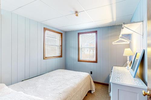 een kleine slaapkamer met een bed en 2 ramen bij Shimmering Seaview in York