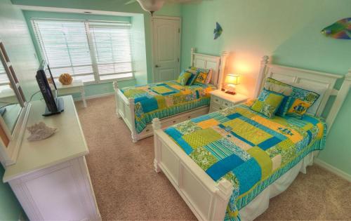 een slaapkamer met 2 bedden en een raam bij Coquina Beach Club 203 in Bradenton Beach