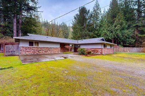 a brick house with a driveway in a yard at The Lake's Hidden Gem in Snoqualmie