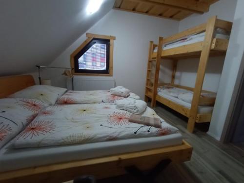a bedroom with two bunk beds and a window at Zrub Jánošík in Valča