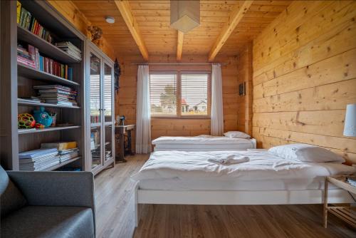 a bedroom with two beds and a book shelf at Dom Lawendowy w Winnicy Nad Źródłem in Sierzawy