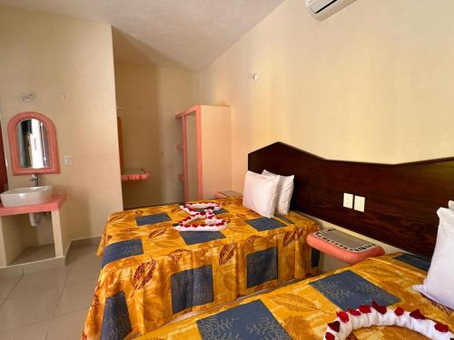 1 dormitorio con 1 cama con edredón amarillo y azul en Hotel Posada Purépechas en Zihuatanejo