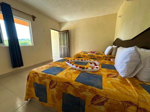 Habitación de hotel con 2 camas y colcha colorida en Hotel Posada Purépechas, en Zihuatanejo
