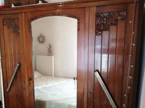 a wooden cabinet with a mirror in a bedroom at Parnassos cottage 