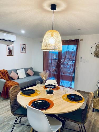 a living room with a table with chairs and a couch at Gîte chez EsTé in Mittelwihr