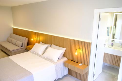 1 dormitorio pequeño con 1 cama y 1 silla en Apartamento Vista Mar 2 quartos em Condomínio Clube a 100 metros da Praia do Campeche, Florianópolis, en Florianópolis