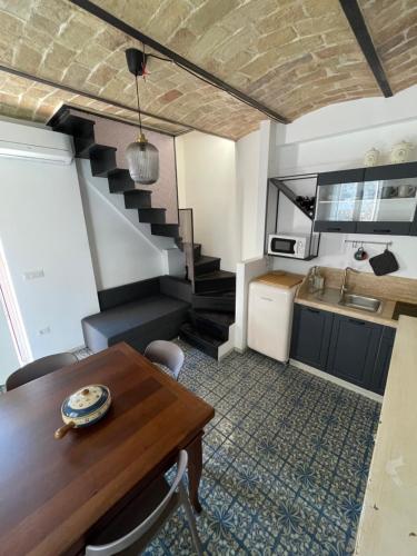 a kitchen and dining room with a table and a staircase at Al Civico 2 in Atri