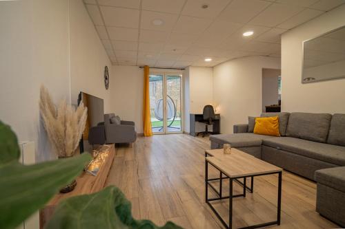 uma sala de estar com um sofá e uma mesa em Maison ville Familial 50m2 + Jardin - L'atlas Zen em Challans