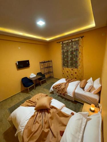 a hotel room with two beds and a television at Palms Garden in Erfoud