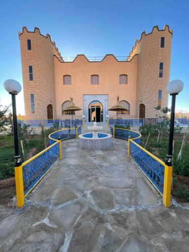 a large brick building with a fountain in front of it at Palms Garden in Erfoud
