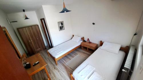 a small room with two beds and a wooden floor at Šumatovac in Aleksinac