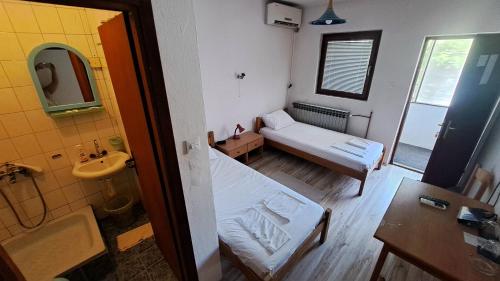 a small room with a bed and a bathroom at Šumatovac in Aleksinac