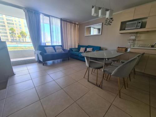 een woonkamer met een tafel en een blauwe bank bij Dpto duplex 2 dormitorios 2 baños en Laguna Vista ,Algarrobo in Algarrobo