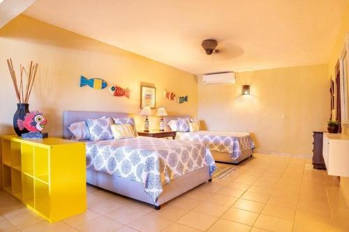 CajuilesにあるGolf Villa en Casa de Campoのベッドルーム1室(ベッド2台、ランプ付きテーブル付)