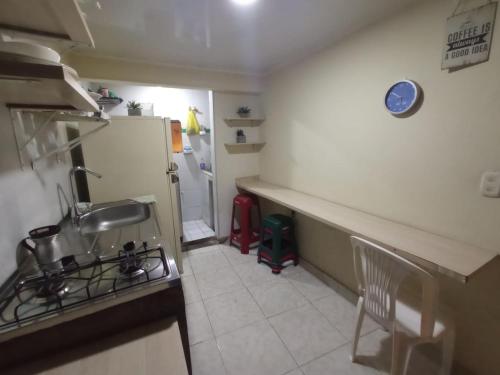 a small kitchen with a sink and a refrigerator at Hostal El Mohan in Neiva