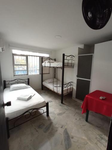 a room with two bunk beds and a table at Hostal El Mohan in Neiva