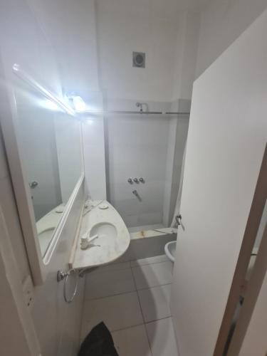W białej łazience znajduje się umywalka i lustro. w obiekcie Departamento Alto Palermo w BuenosAires
