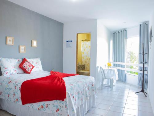 a bedroom with a bed with a red blanket at Pisom Hotel in Santo André