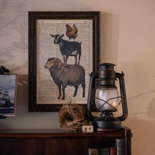 a picture of sheep and chickens on a shelf with a lamp at Hideaway Farmlet Romantic Cottage with Miniature Goats in Penguin