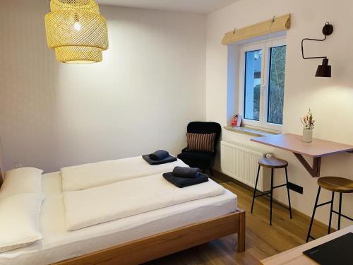 een slaapkamer met een bed, een tafel en een stoel bij Alte Seifensiederei - Malala in Bad Tölz