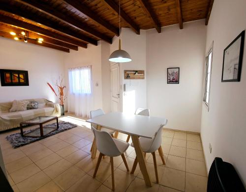 een woonkamer met een witte tafel en stoelen bij Departamento Alto Malbec in La Cieneguita