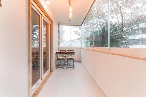 a room with a large window and chairs in it at Cascais Beach Flower Apartment in Estoril