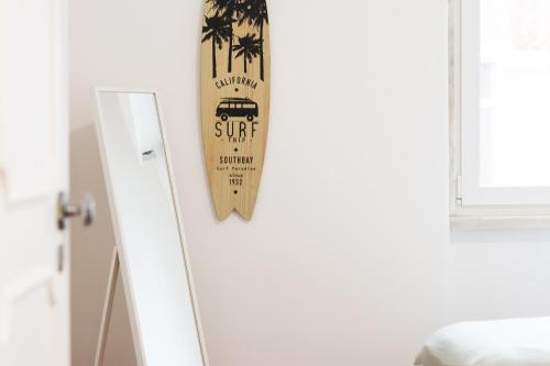 a surfboard hanging on a wall next to a door at Cascais Beach Flower Apartment in Estoril