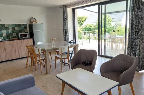 une cuisine et une salle à manger avec une table et des chaises dans l'établissement Le Sanderling, à Trégunc