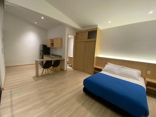 馬尼薩萊斯的住宿－Estar Apartahotel，一间卧室配有一张床、一张桌子和一张桌子