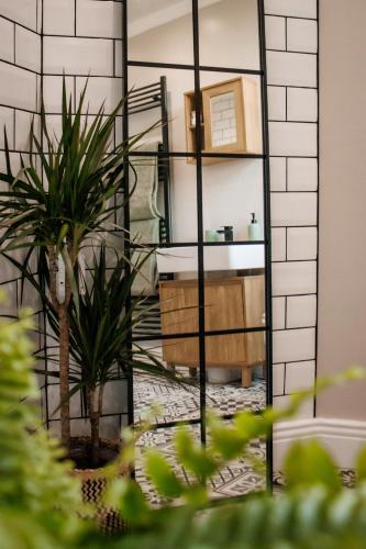 a bathroom with a mirror and a sink and plants at Paupies Place Seaside Stay in Cullercoats