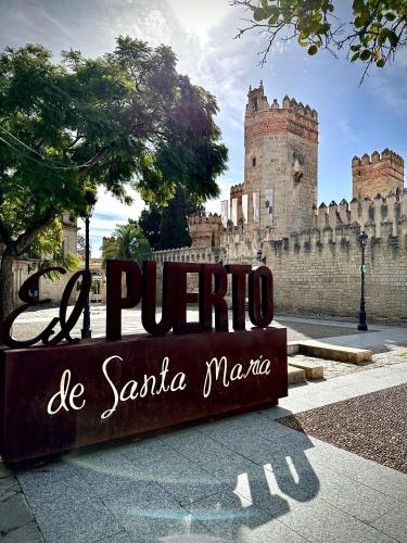 a sign in front of a building with a castle at Puerto Amazonas apartamento con jacuzzi privado in El Puerto de Santa María