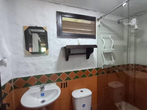 W łazience znajduje się umywalka, lustro i toaleta. w obiekcie Chalet MOKA la Riviera w mieście Calima
