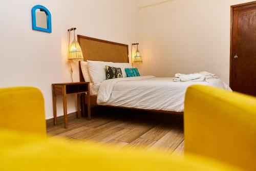 a bedroom with a bed and a nightstand with a bed sidx sidx at Aaki Hotel in Las Peñitas