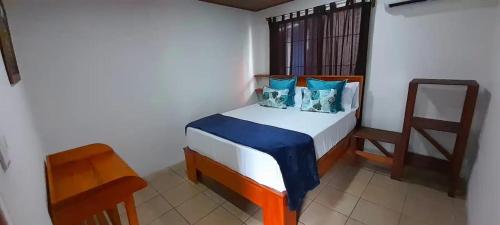 a small bedroom with a bed and a chair at River Place in Fortuna