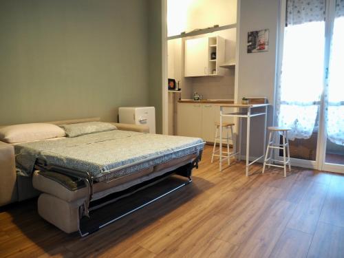 a bedroom with a bed and a kitchen with a table at Leo’s Home in Sesto San Giovanni