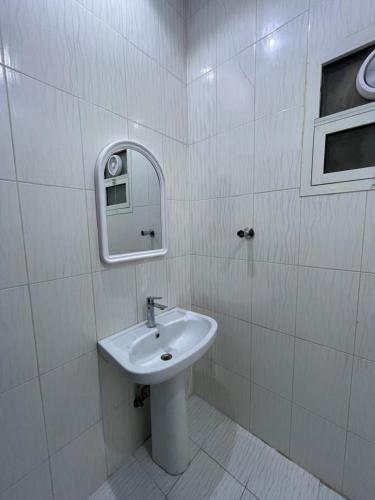 La salle de bains blanche est pourvue d'un lavabo et d'un miroir. dans l'établissement استديو, à Riyad