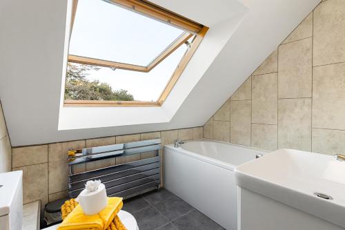 a bathroom with a tub and a sink and a window at Beautiful Whole Home in Torbay, Walking Distance to Beach, Centre and Harbour in Torquay