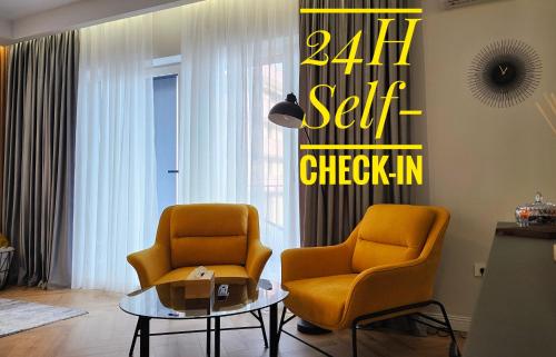 two chairs and a table in a living room at Akis CityChic Apartment in Cluj-Napoca