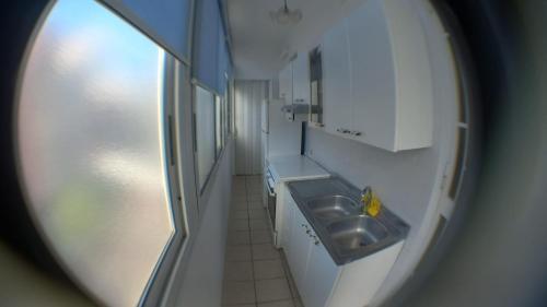 una piccola cucina con lavandino e specchio di OASI CL a Bari