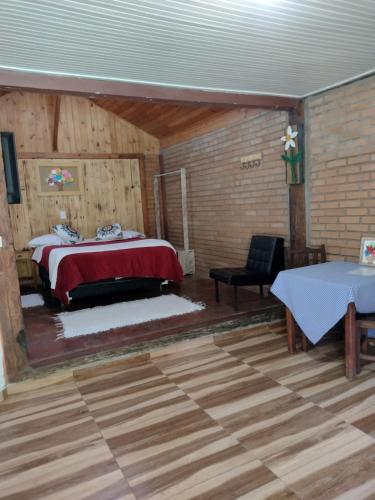 a bedroom with a bed and a table in a room at Pousada Toque de Minas in Visconde De Maua