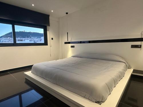 Bett in einem Zimmer mit einem großen Fenster in der Unterkunft Casa Boulevard in Jaén