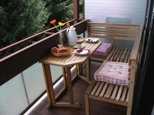 a table and bench on a balcony with a table and chairs at Ferienwohnung Christa in Bad Peterstal-Griesbach