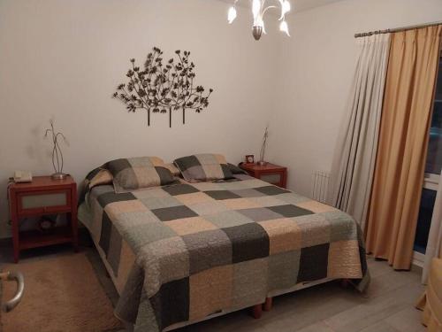 a bedroom with a bed with a checkered blanket at Apartamento frente al Mar para 7 in Pinamar
