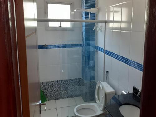 a bathroom with a toilet and a glass shower at COBERTURA Duplex com vista do Mar, Condomínio Village das ondas in Piúma