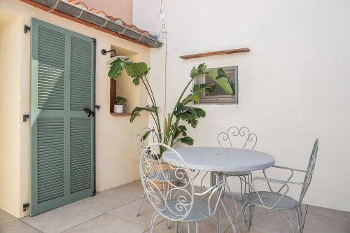 une table et des chaises sur une terrasse avec une plante dans l'établissement Charmante maison en bord de mer, à Banyuls-sur-Mer