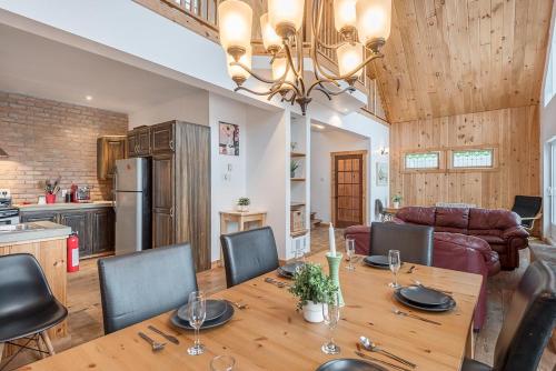 una cucina e una sala da pranzo con tavolo e sedie in legno di Rustic Waterfront Chalet Panoramic View and Spa a Chertsey