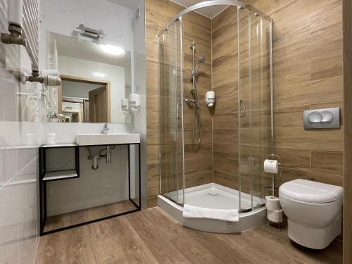 a bathroom with a shower and a toilet and a sink at Miejsca noclegowe w Arka Medical SPA in Kołobrzeg