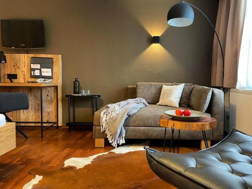 a living room with a couch and a table at moser-HOCHKÖNIG Genuss Wirtshaus Hotel in Maria Alm am Steinernen Meer