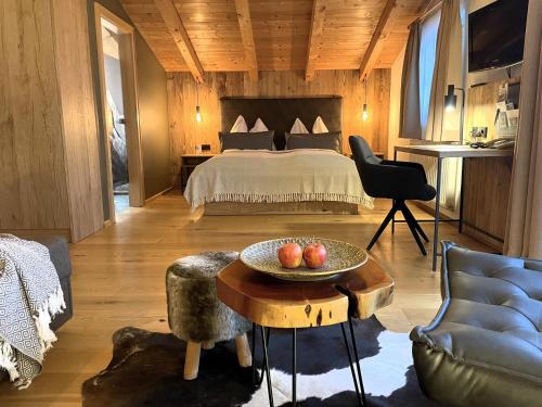 Un dormitorio con una cama y una mesa con manzanas. en moser-HOCHKÖNIG Genuss Wirtshaus Hotel, en Maria Alm am Steinernen Meer